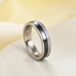 Black and white 5.5 mm ceramic spinner ring with a single row of decorative stones